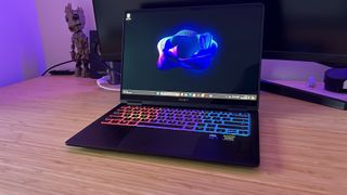 HP Omen Transcend 14 gaming laptop sitting on a wooden desk with a monitor behind